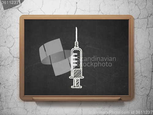 Image of Medicine concept: Syringe on chalkboard background