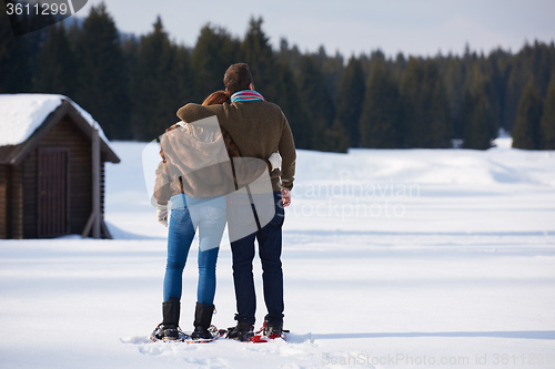 Image of couple having fun and walking in snow shoes