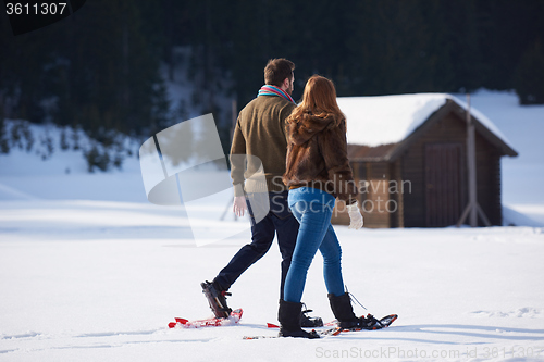 Image of couple having fun and walking in snow shoes