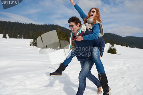 Image of happy young couple having fun on fresh show on winter vacation