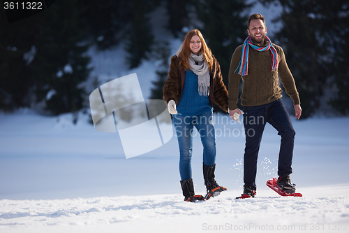 Image of couple having fun and walking in snow shoes