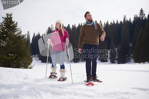 Image of couple having fun and walking in snow shoes