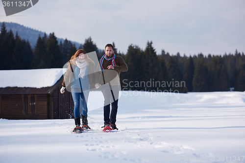 Image of couple having fun and walking in snow shoes