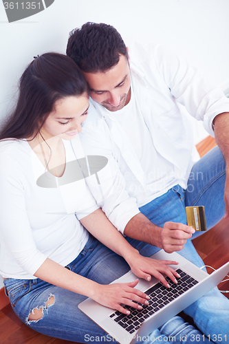 Image of relaxed young couple working on laptop computer at home