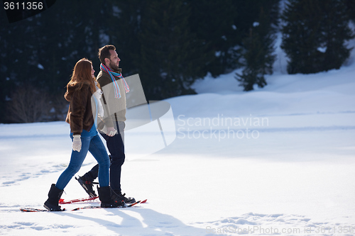 Image of couple having fun and walking in snow shoes