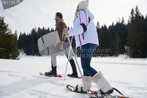 Image of couple having fun and walking in snow shoes