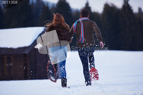 Image of couple having fun and walking in snow shoes