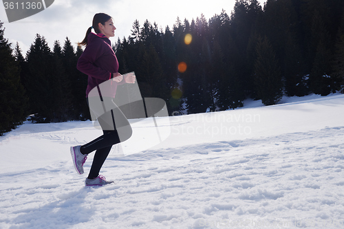 Image of yougn woman jogging outdoor on snow in forest