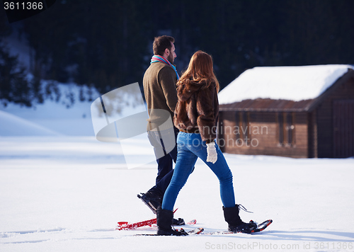 Image of couple having fun and walking in snow shoes