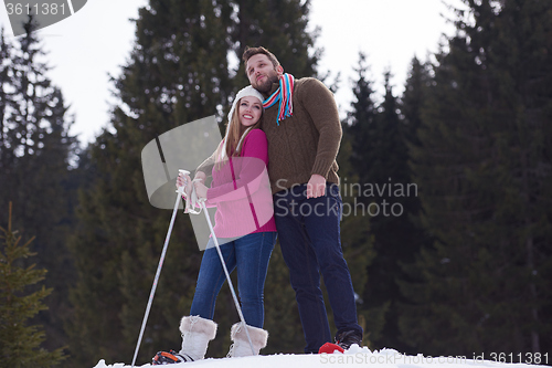 Image of couple having fun and walking in snow shoes