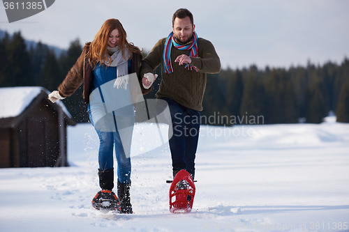 Image of couple having fun and walking in snow shoes