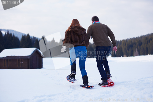 Image of couple having fun and walking in snow shoes