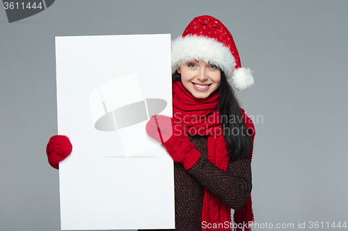 Image of Woman in Santa hat holding white banner
