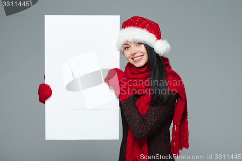 Image of Woman in Santa hat holding white banner