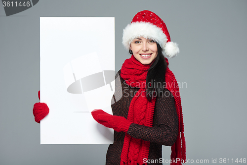 Image of Woman in Santa hat holding white banner