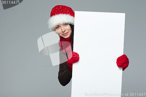 Image of Woman in Santa hat holding white banner