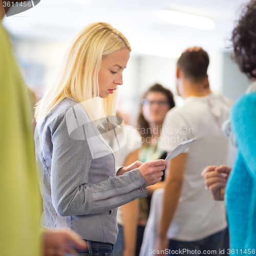 Image of Young blond caucsian woman waiting in line.