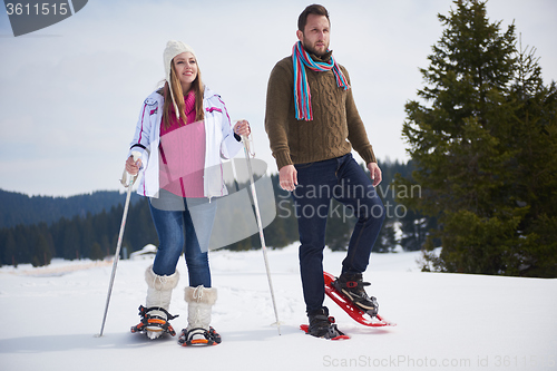 Image of couple having fun and walking in snow shoes