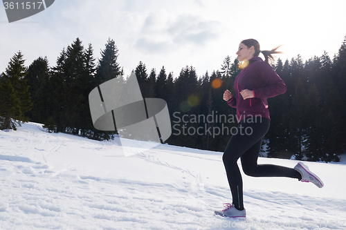 Image of yougn woman jogging outdoor on snow in forest