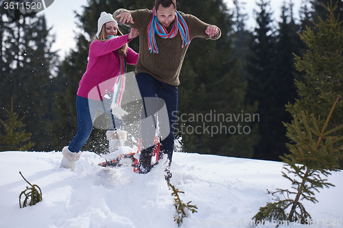 Image of couple having fun and walking in snow shoes