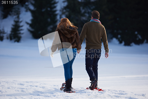 Image of couple having fun and walking in snow shoes