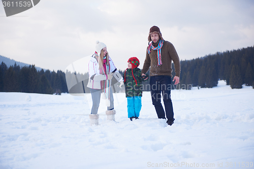 Image of happy family playing together in snow at winter