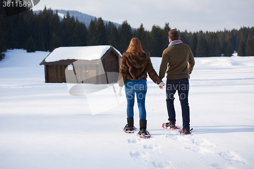 Image of couple having fun and walking in snow shoes