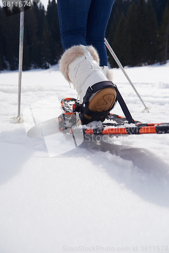 Image of couple having fun and walking in snow shoes