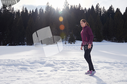 Image of yougn woman jogging outdoor on snow in forest