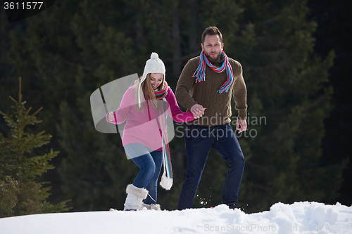 Image of couple having fun and walking in snow shoes