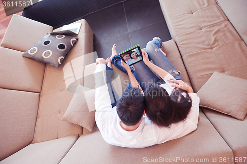 Image of couple at modern home using tablet computer