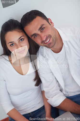 Image of relaxed young couple working on laptop computer at home