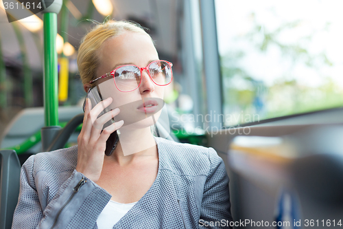 Image of Blonde business woman traveling by bus.