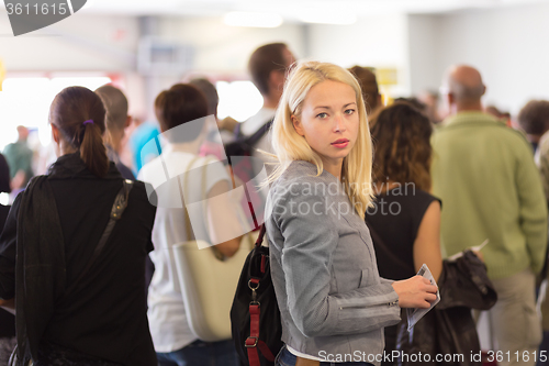 Image of Young blond caucsian woman waiting in line.