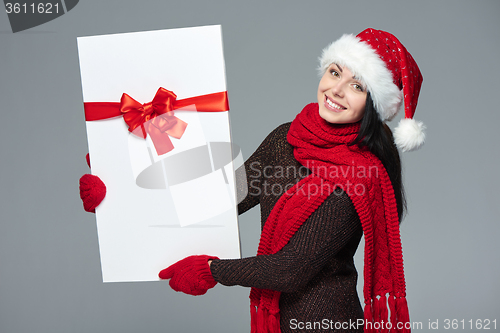 Image of Woman in Santa hat holding white banner