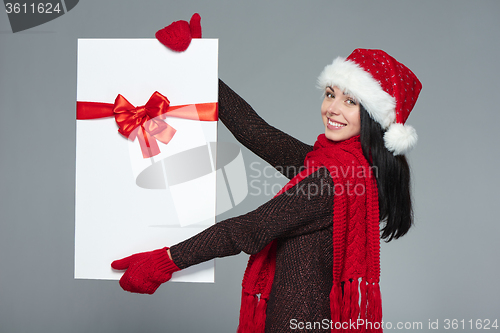 Image of Woman in Santa hat holding white banner