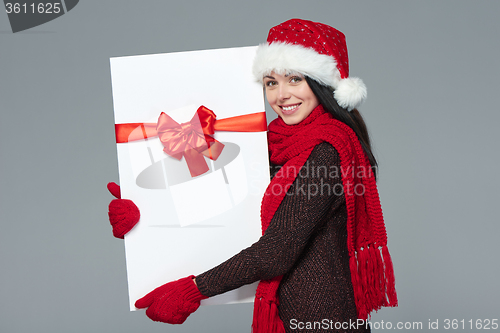 Image of Woman in Santa hat holding white banner