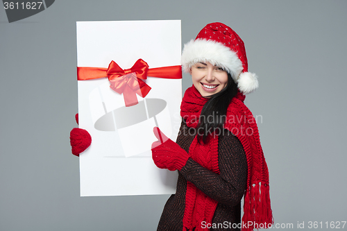 Image of Woman in Santa hat holding white banner