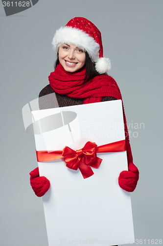 Image of Woman in Santa hat holding white banner