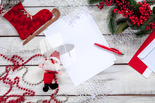 Image of The blank sheet of paper on the wooden table with a pen 