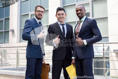 Image of Portrait of business team holding their thumbs up