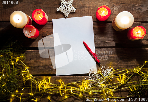 Image of The blank sheet of paper on the wooden table with a pen 