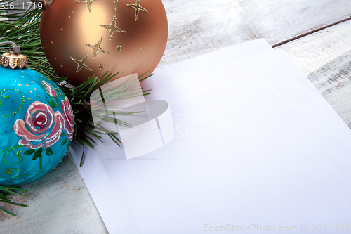 Image of The sheet of paper on wooden table with Christmas decorations 