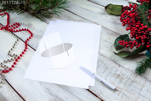 Image of The blank sheet of paper on the wooden table with a pen 