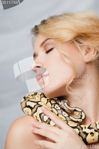 Image of Beautiful girl  holding a python, which wraps around her body