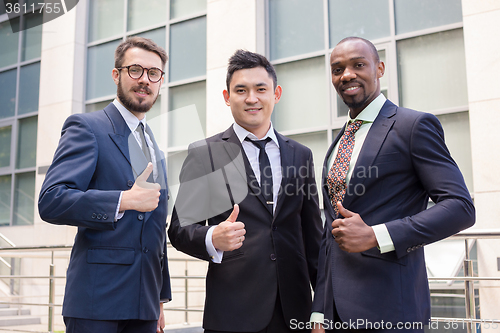 Image of Portrait of business team holding their thumbs up