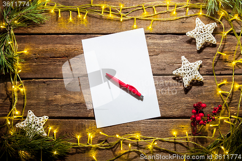 Image of The blank sheet of paper on the wooden table with a pen 