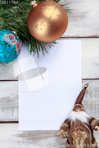 Image of The sheet of paper on wooden table with Christmas decorations 