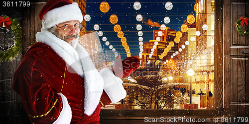 Image of The man in costume of santa claus over  night city background