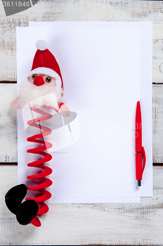 Image of The blank sheet of paper on the wooden table with a pen 